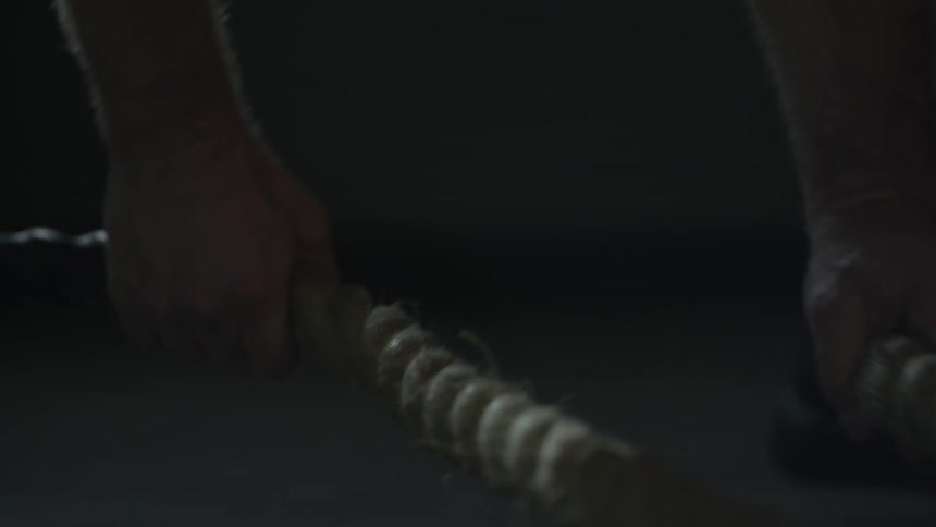 Someone is picking up two thick ropes