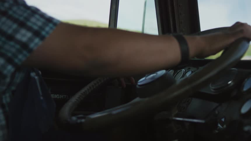 A man is steering his big truck