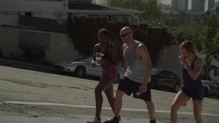 Three people walk uphill after exercising