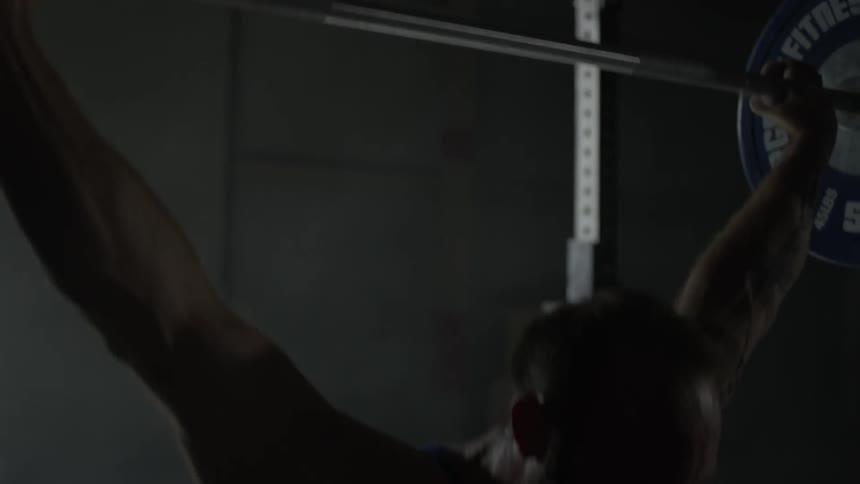 A man is pushing weights over his head
