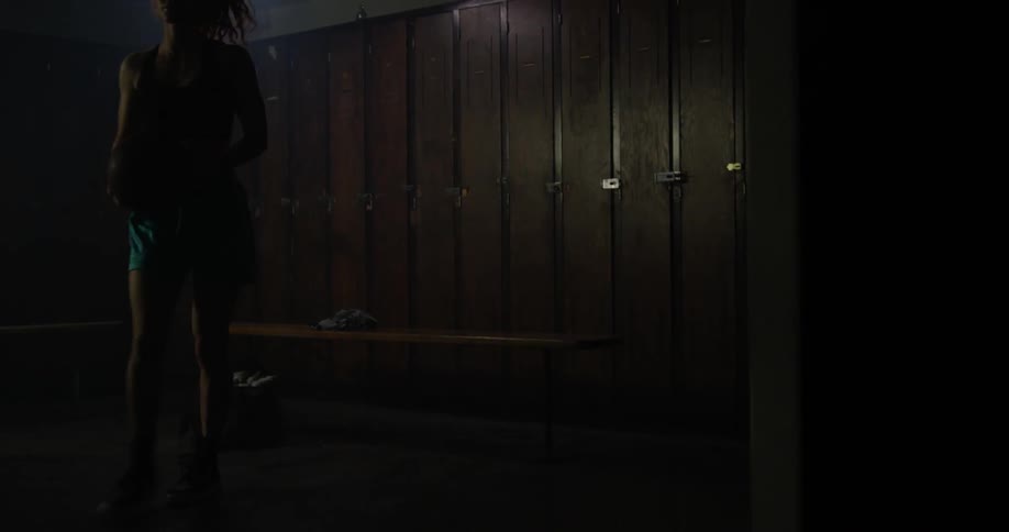 A woman is leaving the locker room to go play basketball
