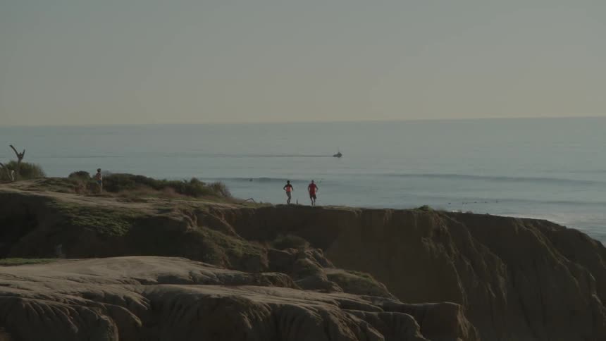 A group of people run along a dirt trail
