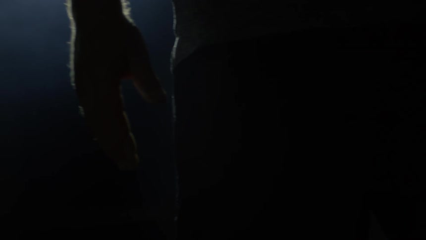 Sunlight shines through a window and onto a man wiggling his fingers