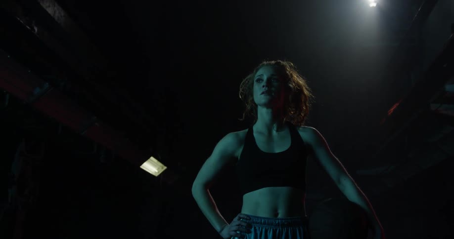 A female basketball player is standing holding a basketball