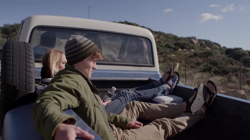 Man and woman sitting in back of truck