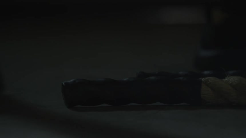A person picks up the heavy rope off the floor