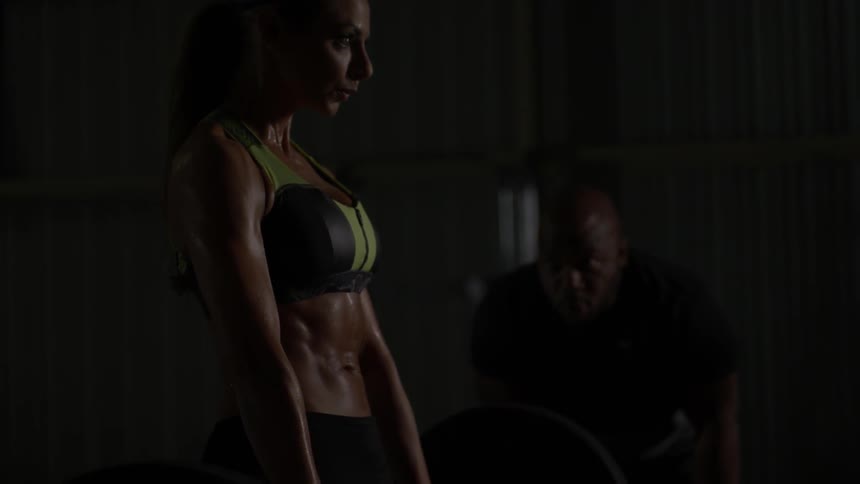 A woman squatting down and lifting weights