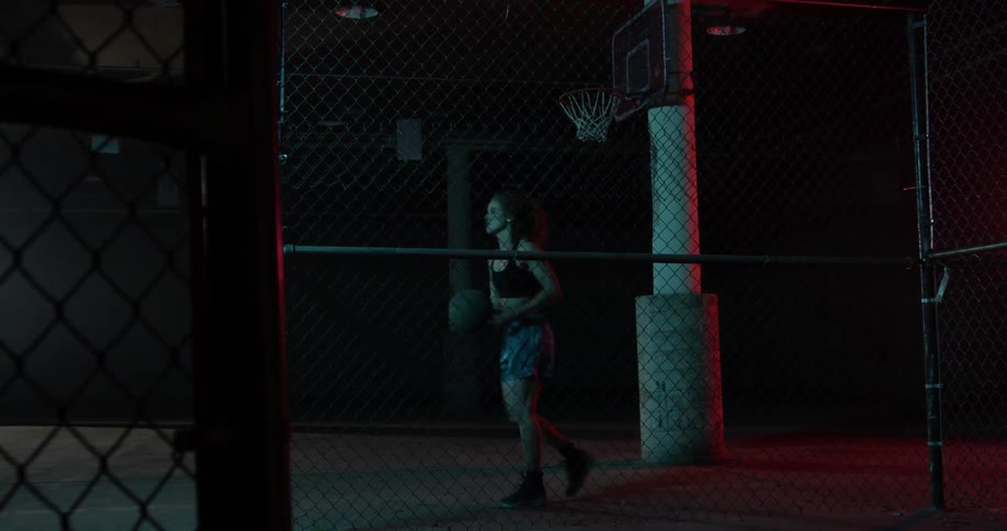 A woman stands up and grabs a basketball