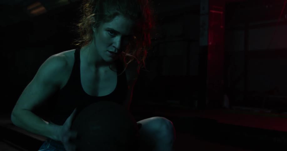 A female athlete is spinning a basketball in her hands