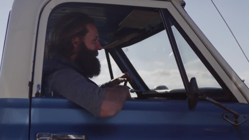 People ride in a blue truck on a sunny day