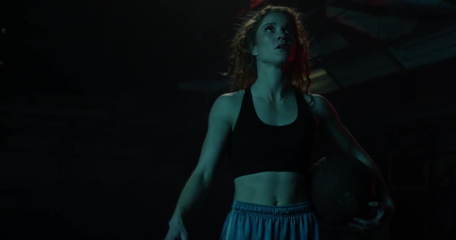 A woman moves a basketball behind her back