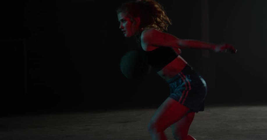 A woman dribbles a basketball between her legs