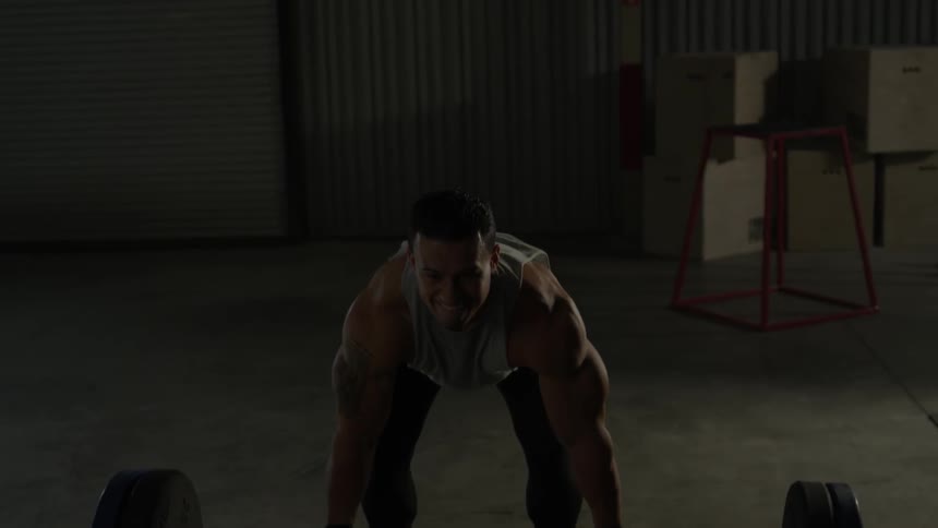 A man lifts a weight up by the bar