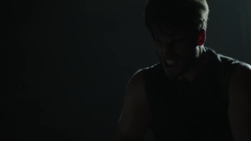 Silhouette of a man pulling hard on ropes very quickly