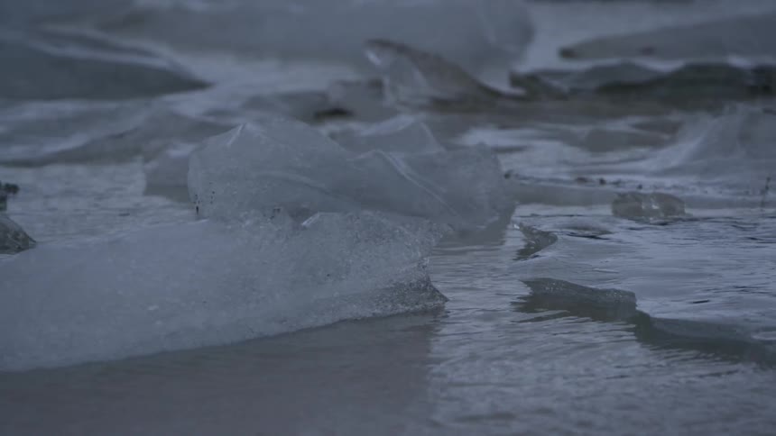 Water flowing between chunks of ice and rocks