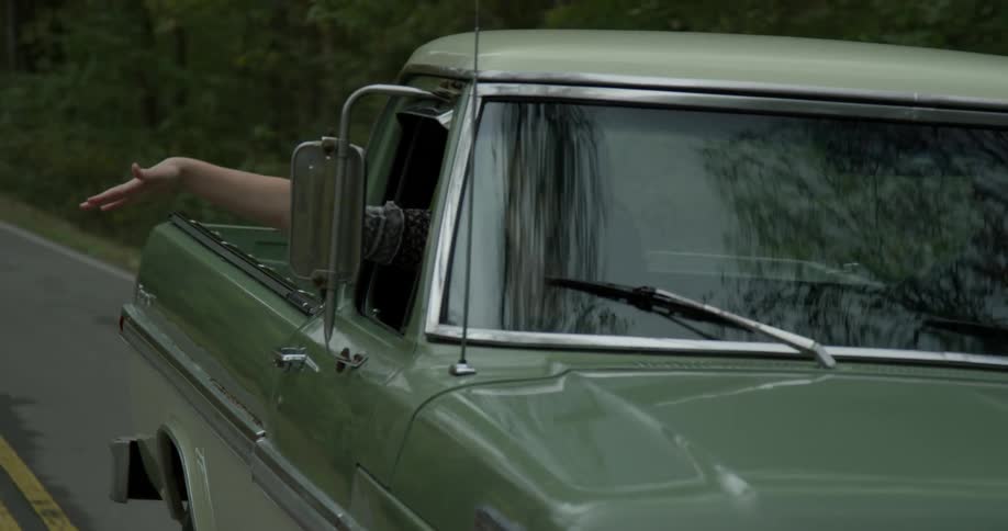 Someone is riding in a truck with their arm out the window