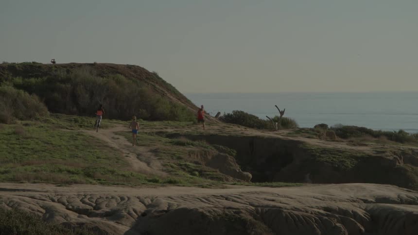 A group of people run along a dirt trail