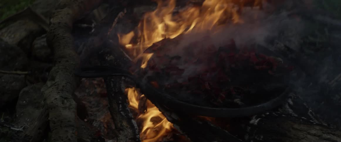 A campfire burns outdoors