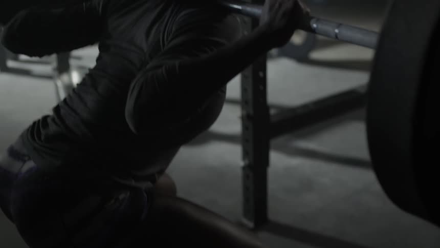 A woman lifts a weight on her back