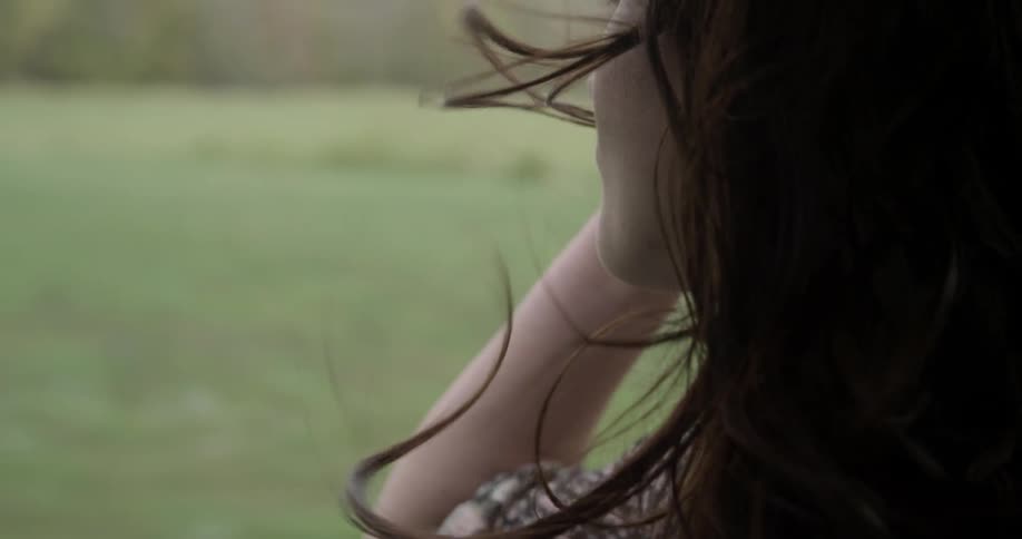 Woman looks out of the window of a moving vehicle