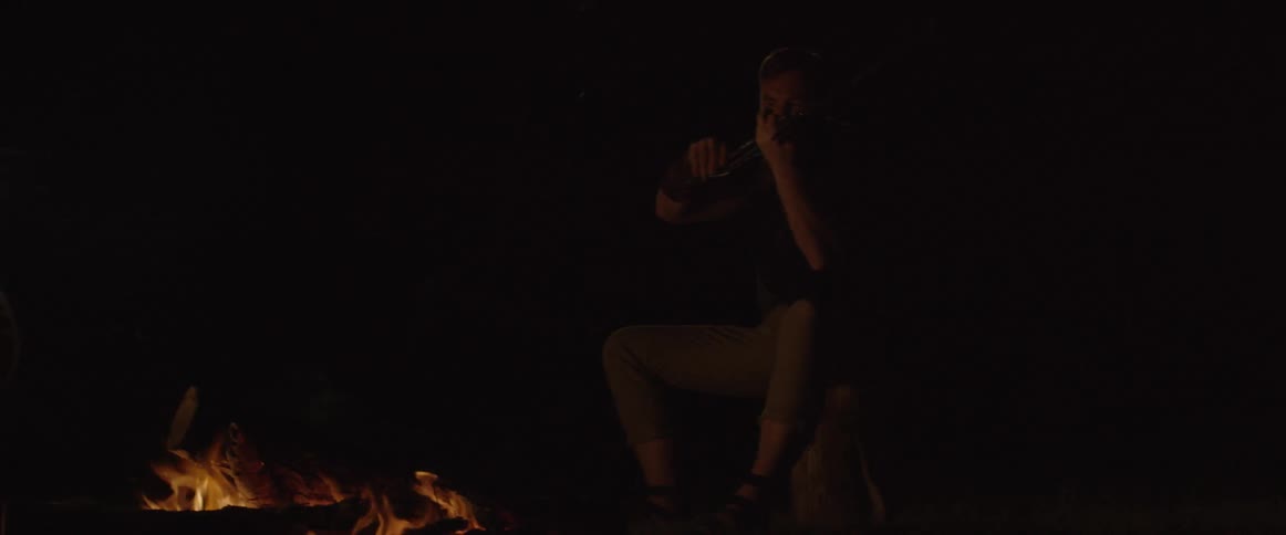 A man is playing the violin by the fire