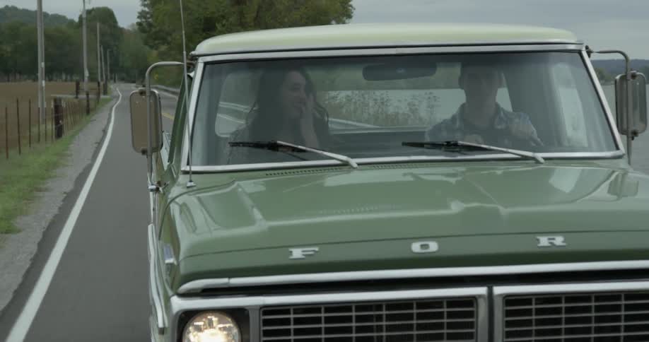 Two people laugh and talk while riding in a ford truck