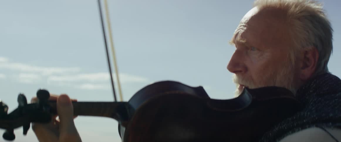 A man abruptly stops playing a violin and looks worried