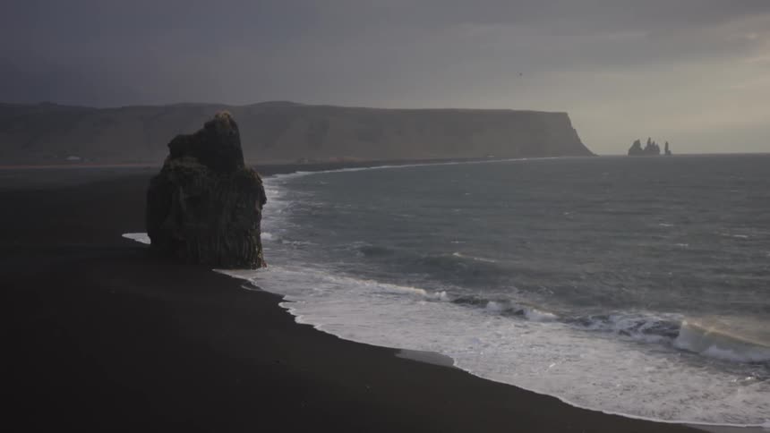 Water hitting against a shore line and the rocks that stay by its side