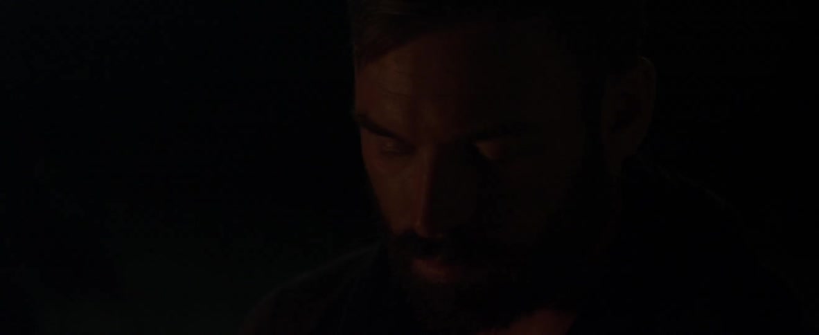 Bearded man blinks his eyes and looks down