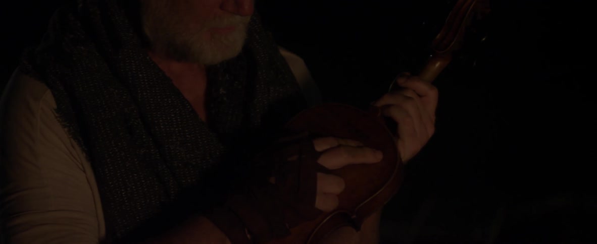 A man looks at his guitar touching the side