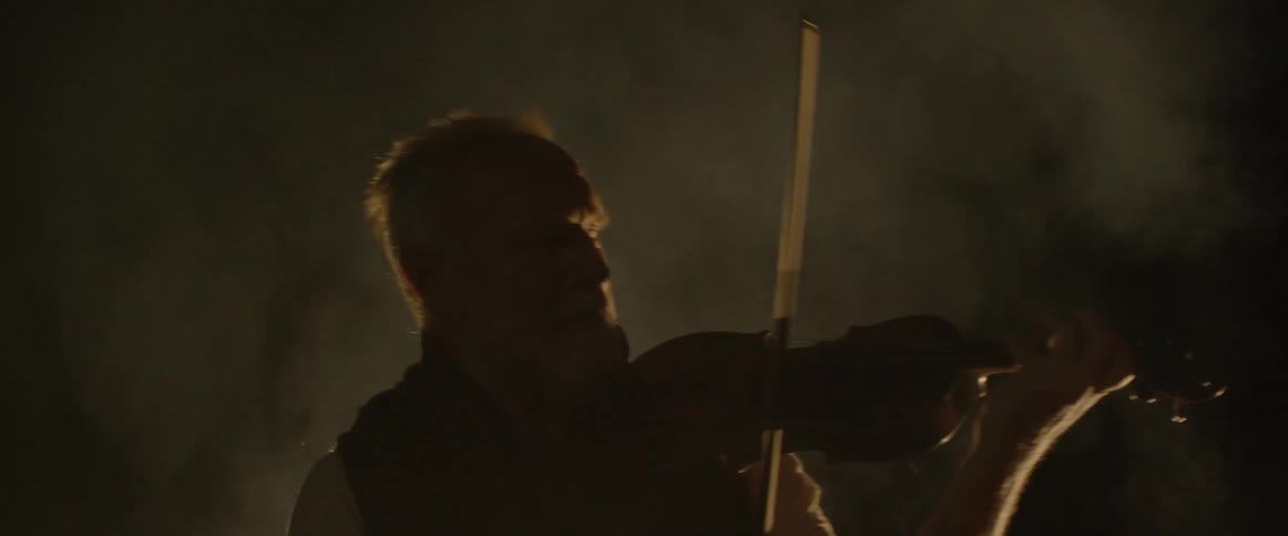 Two men playing violin in the smoke