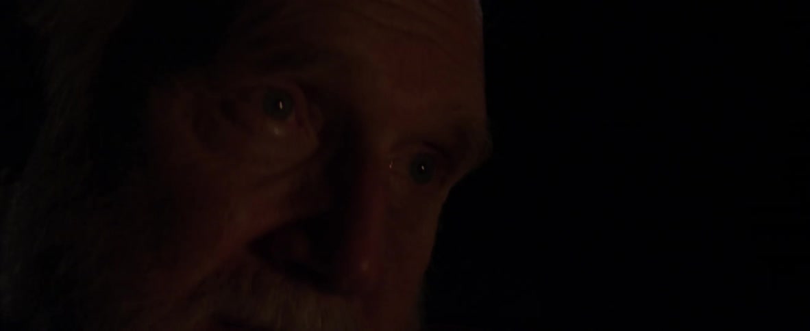 A bearded man sways in the dark