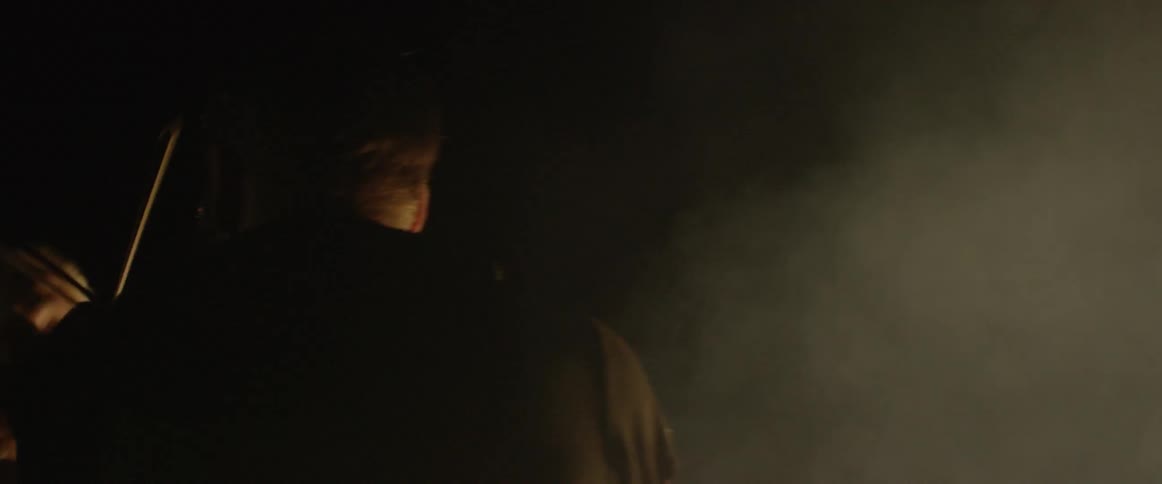 Two violin players play head to head by the fire