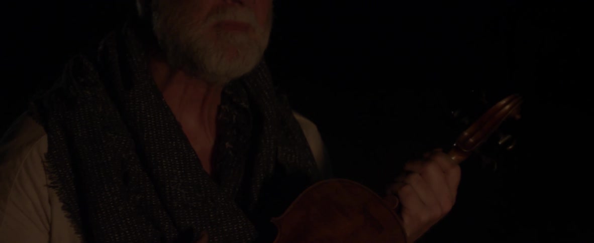 An old man is holding a violin