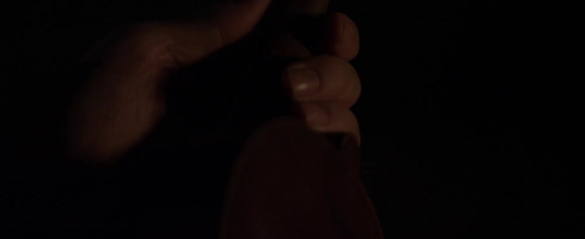 A man is holding the neck of a violin