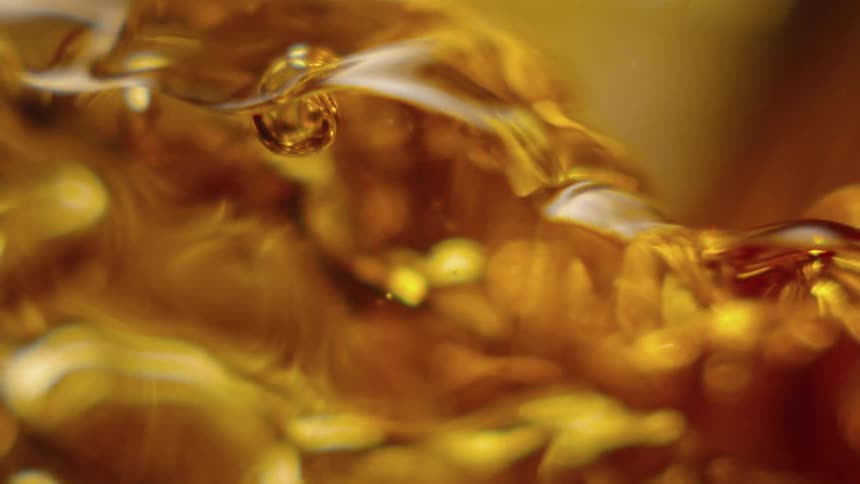 A glass is slowly filling with liquid