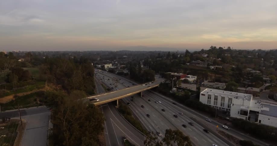 A busy highway cutting through a city filled with trees