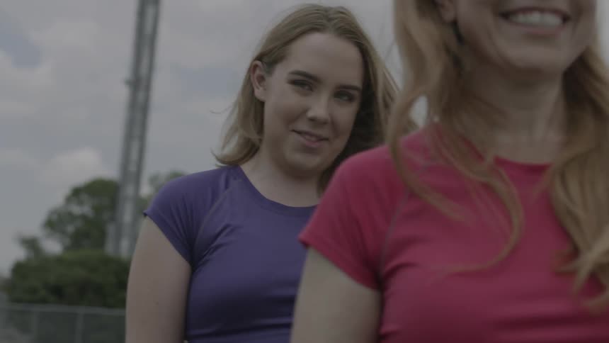 Two ladies are walking and talking and then sit down