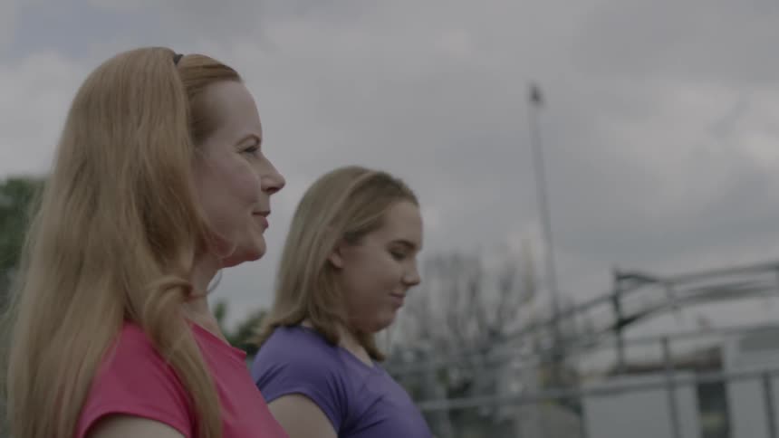 Two women walk outside on a cloudy day