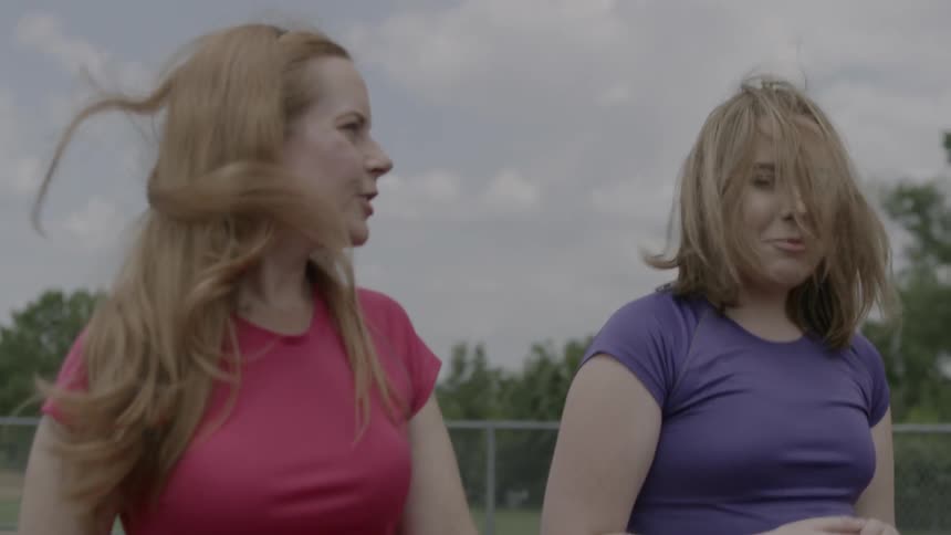 Two women laugh and talk as they walk