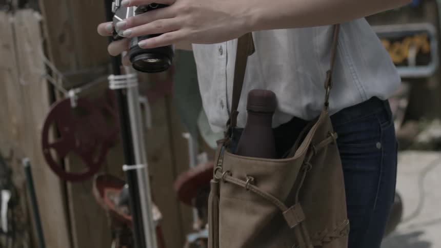 A woman pulls a camera out of her bag