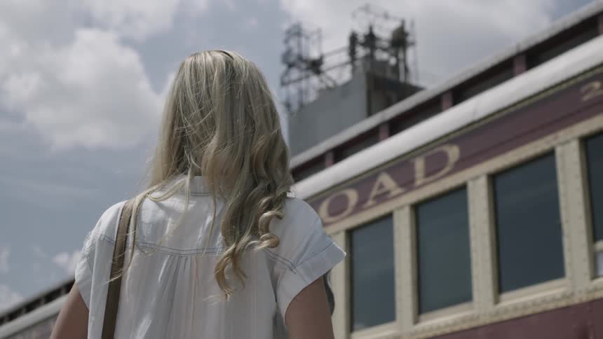 A woman takes a photo of a vintage rail car