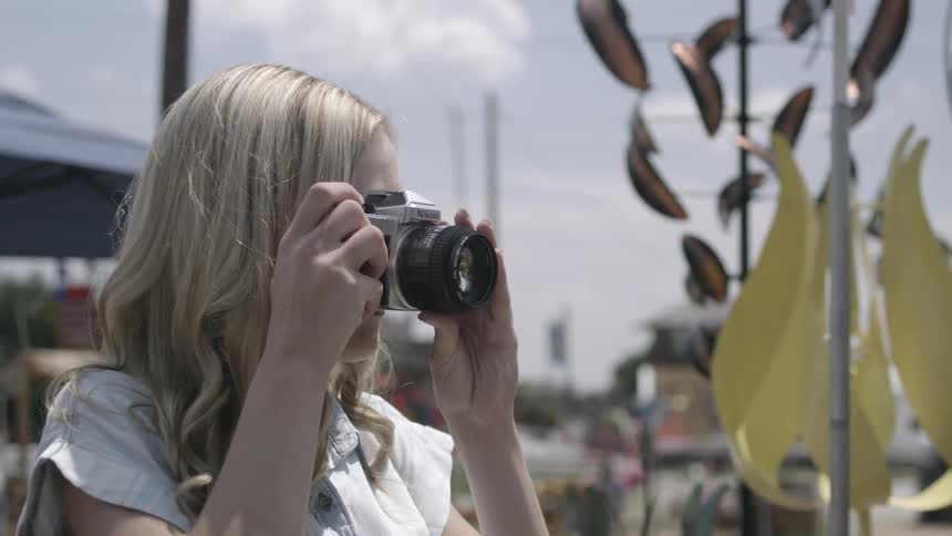 Woman taking a photograph with camera and smiling