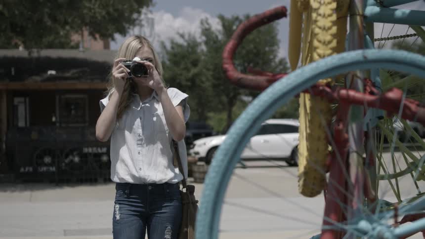 A woman is photographing and smiling