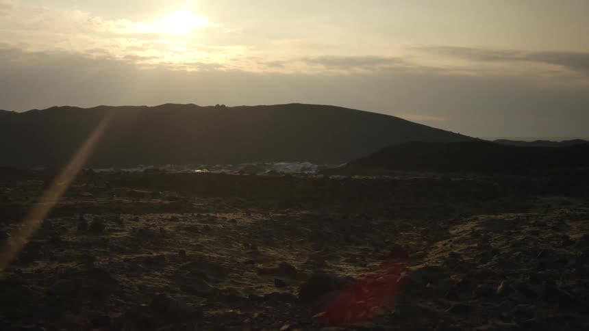 Early morning sun over a hilly desert landscape