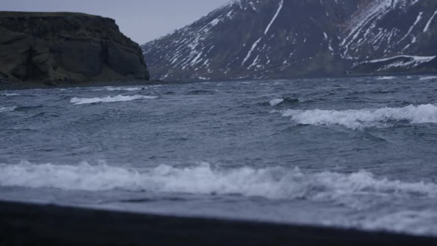 Waves crash on the beach on an overcast day