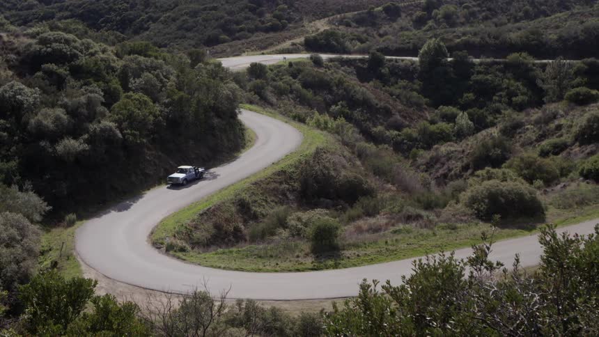 A truck drives on a winding road