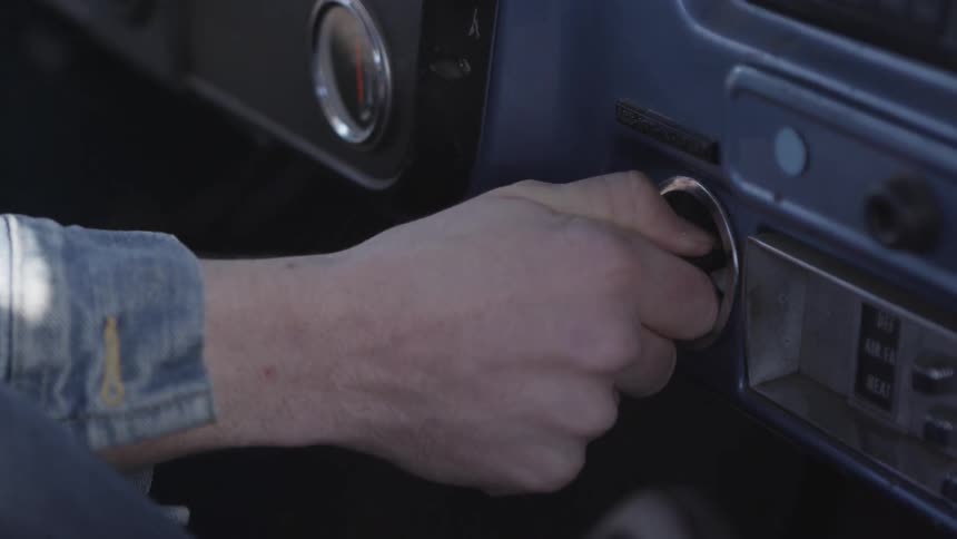 A person turning the ignition key of the vehicle