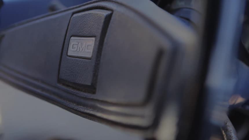 An automotive instrument panel and a person turning a gmc steering wheel