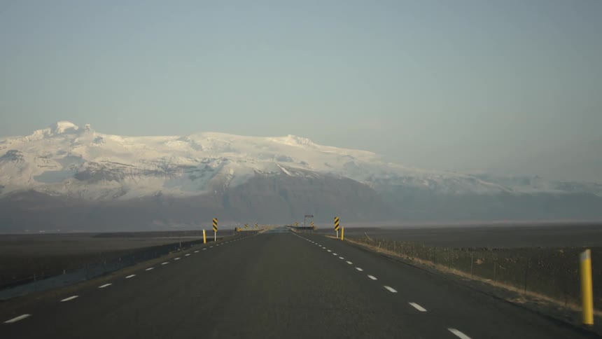 A road and bridge stretches across farm fields